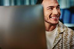 Close up of man looking away from his computer screen